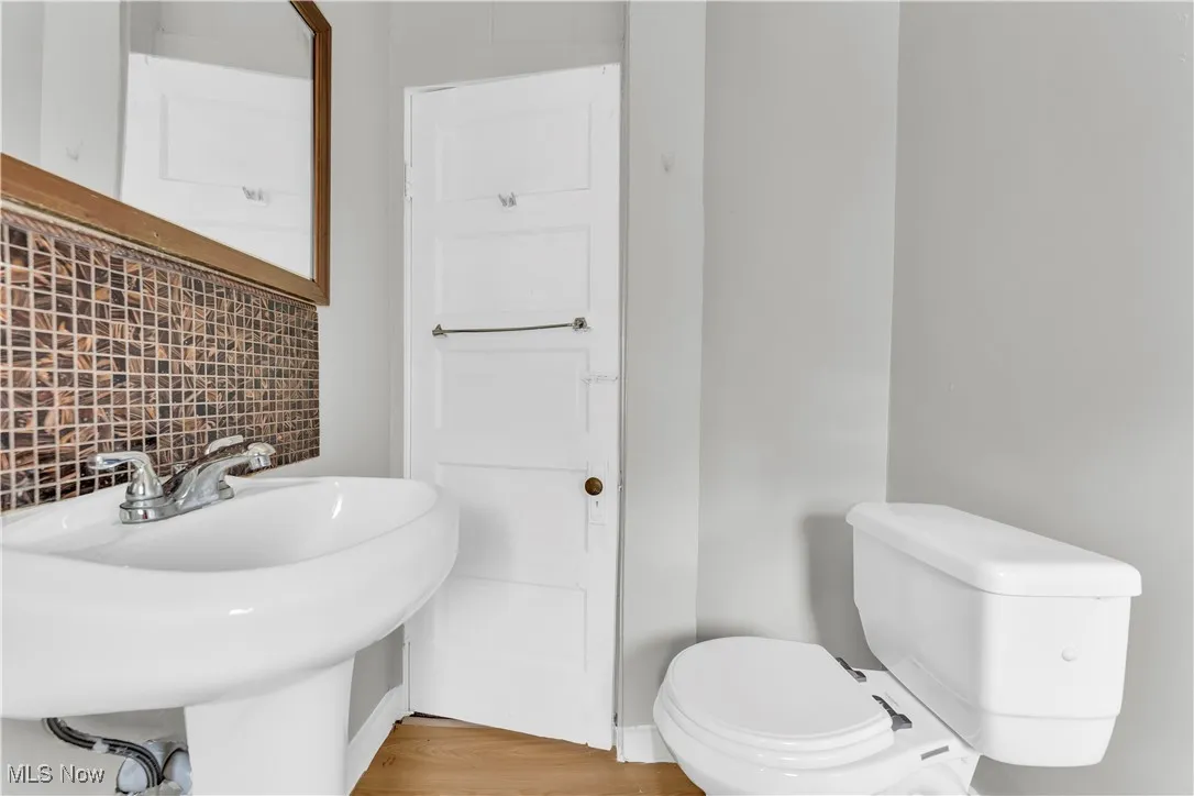 Bathroom with toilet and wood finished floors