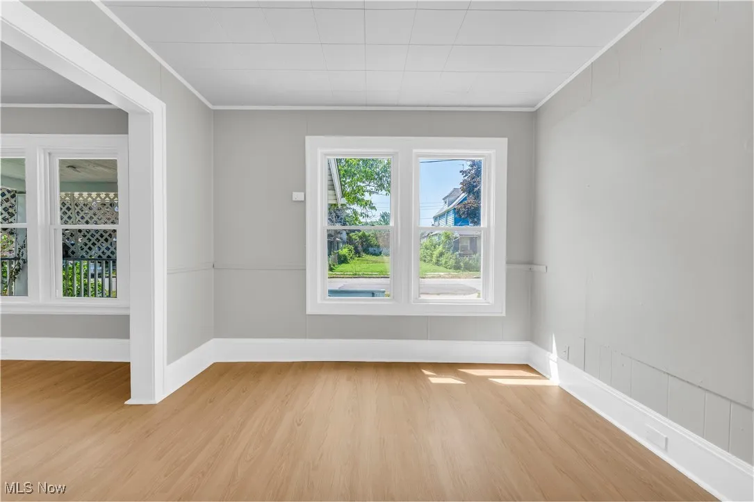 Spare room featuring wood finished floors and ornamental molding