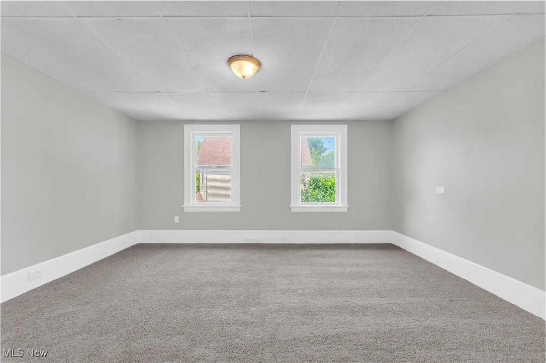 Unfurnished room featuring carpet and baseboards