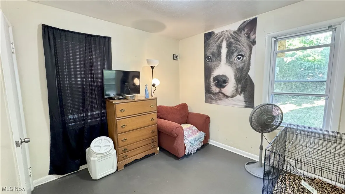 Sitting room featuring baseboards and concrete floors