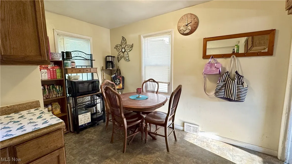 Dining space with baseboards and dark floors