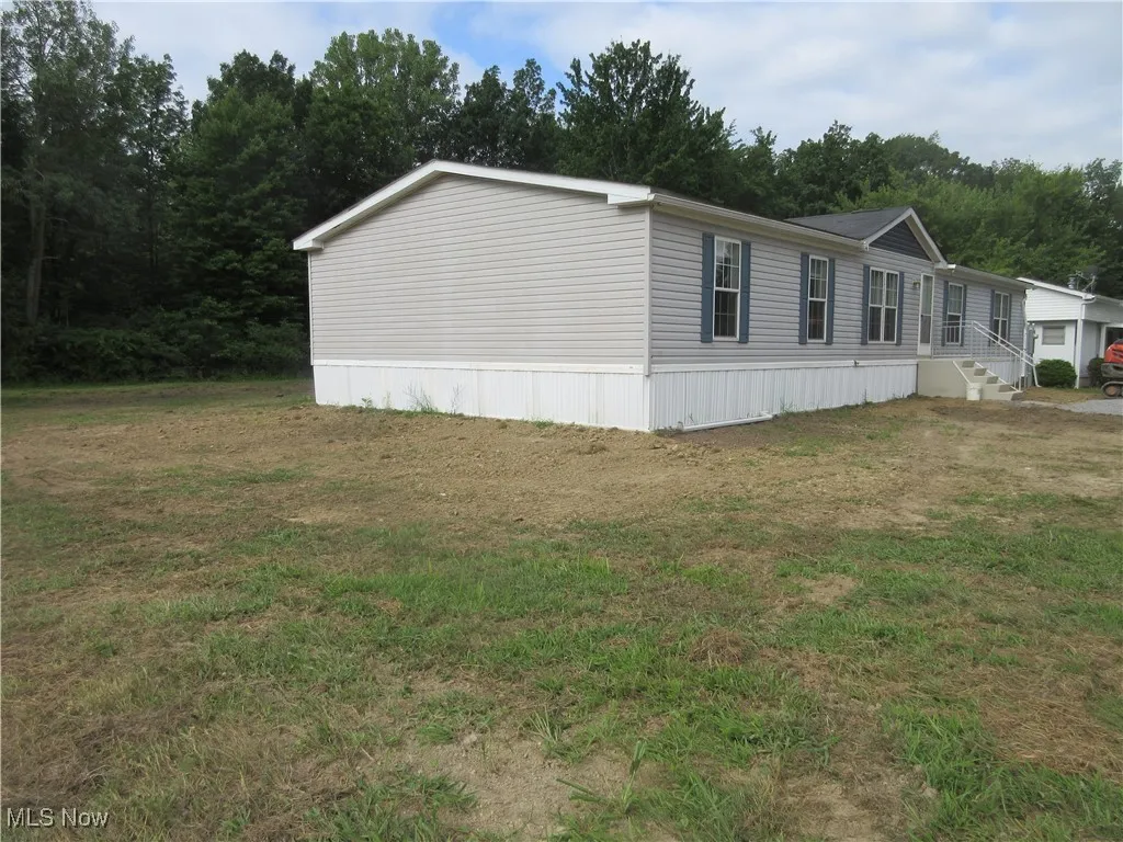 View of side of property featuring a lawn