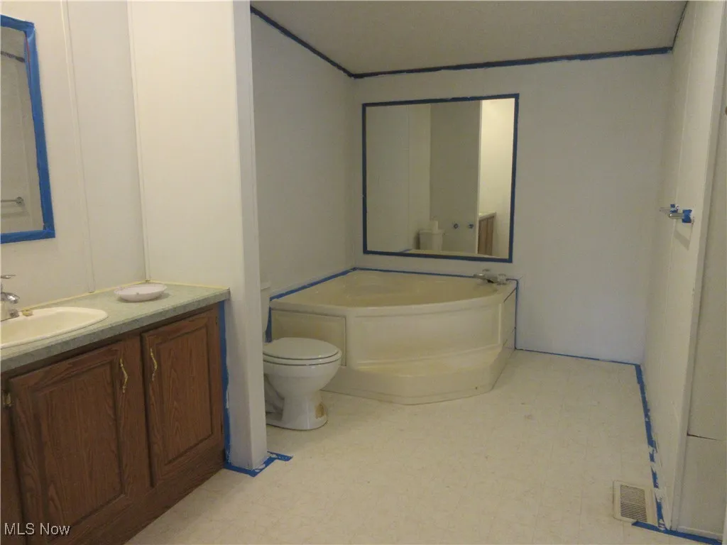 Full bath featuring a bath, vanity, and tile patterned floors