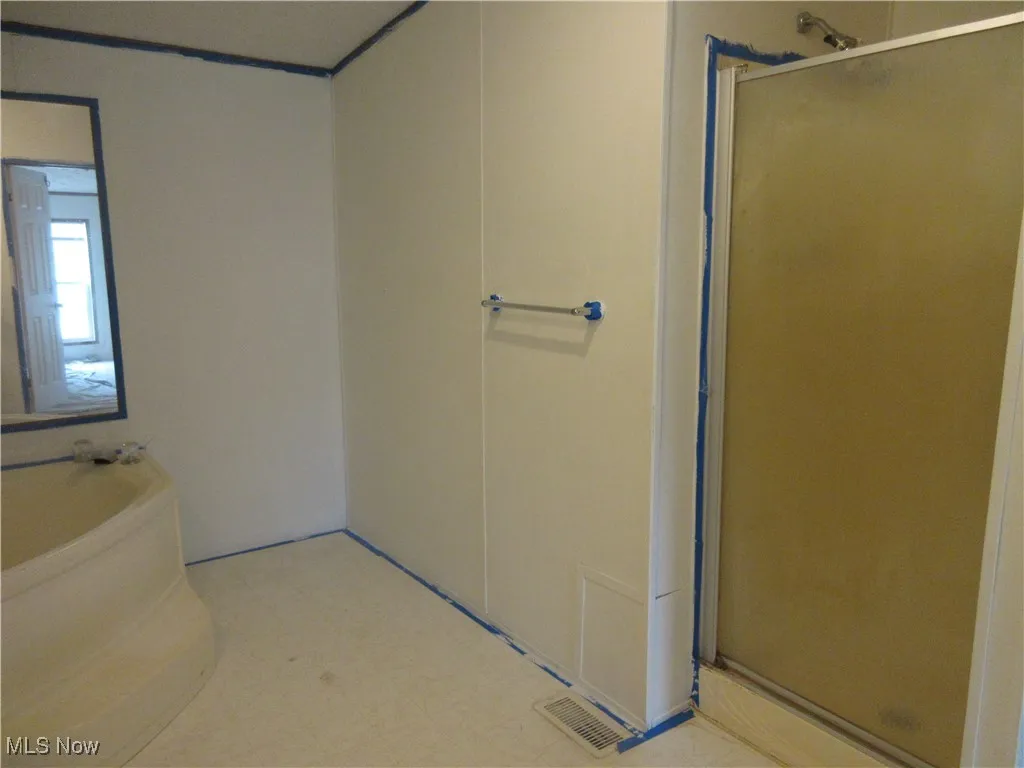 Bathroom with a shower stall, a garden tub, and tile patterned floors