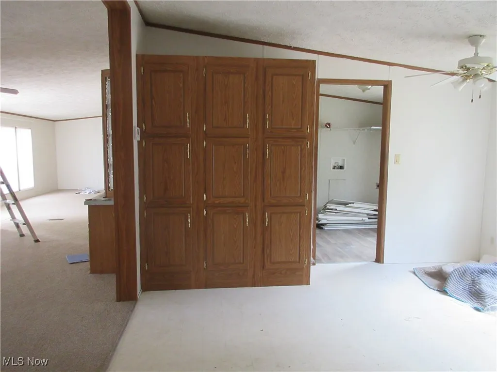 Bedroom with a textured ceiling, crown molding, and a closet