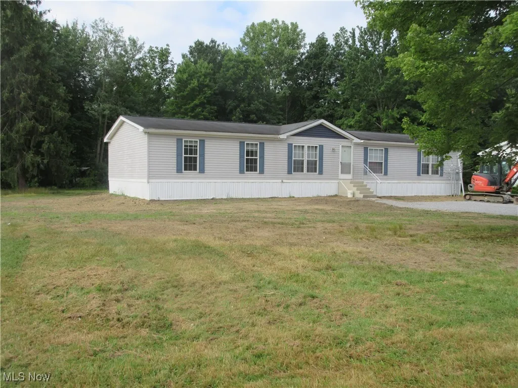 Manufactured / mobile home with entry steps and a front yard
