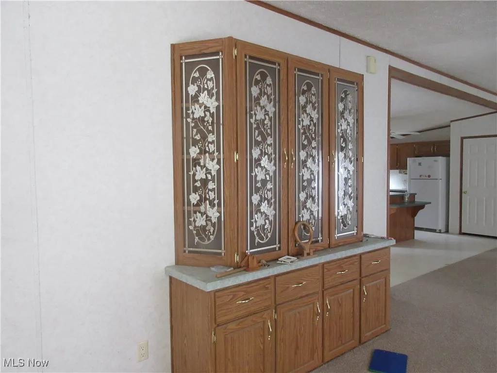 Bar featuring freestanding refrigerator and crown molding