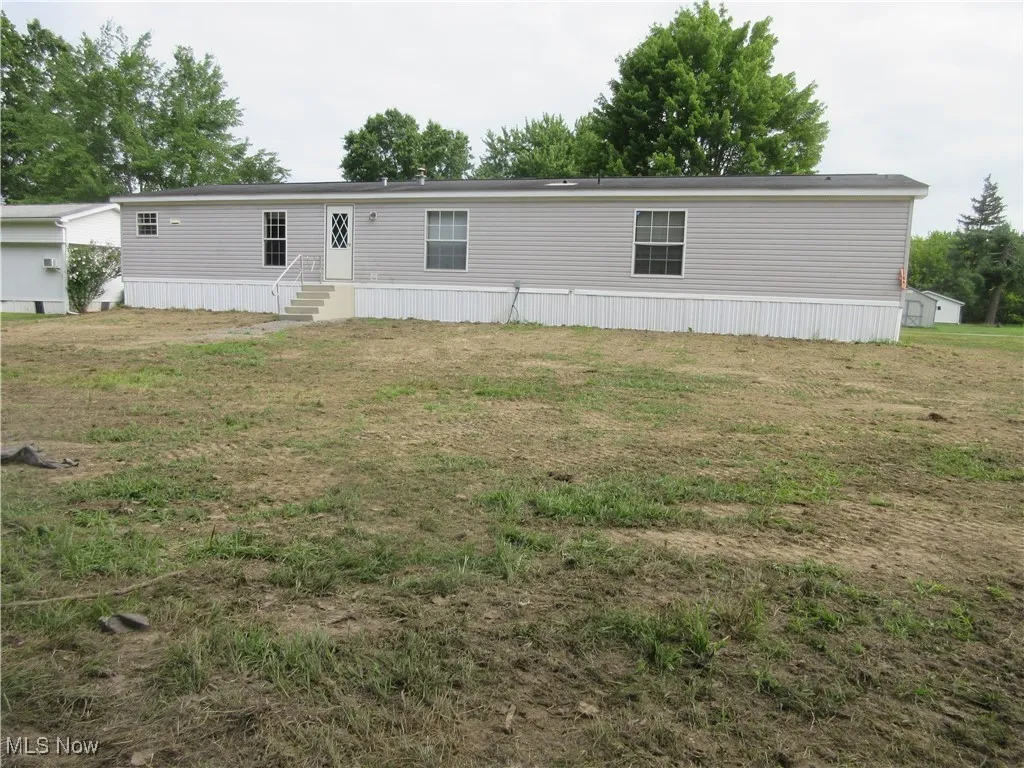 Manufactured / mobile home with entry steps and a front lawn