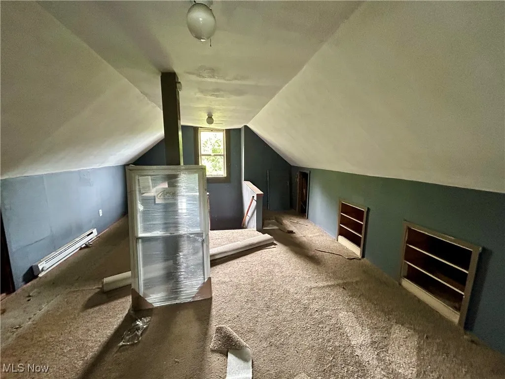 Bonus room featuring carpet floors, a baseboard heating unit, and lofted ceiling