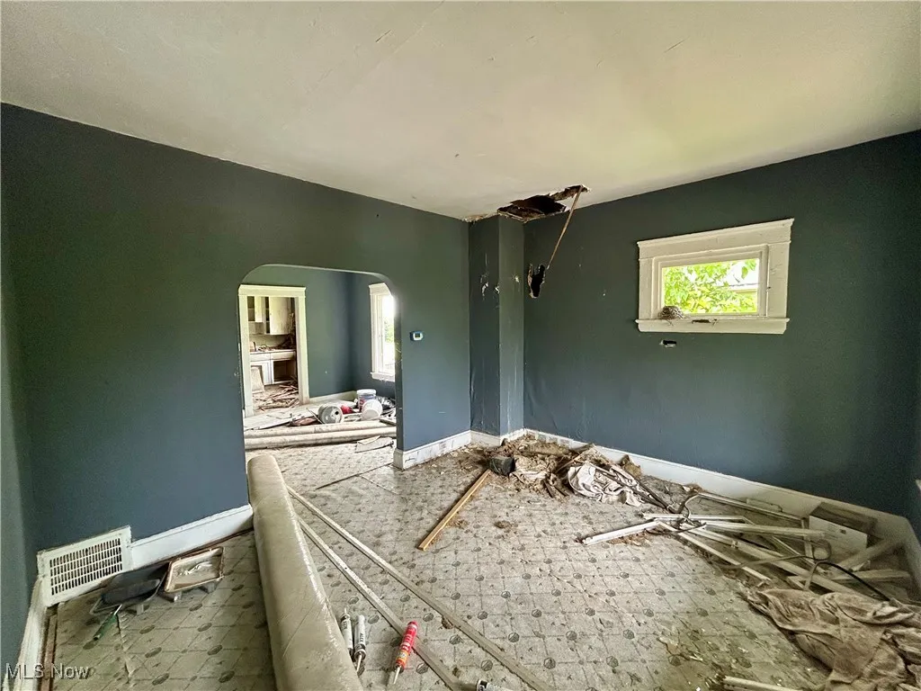 Unfurnished bedroom with arched walkways and baseboards