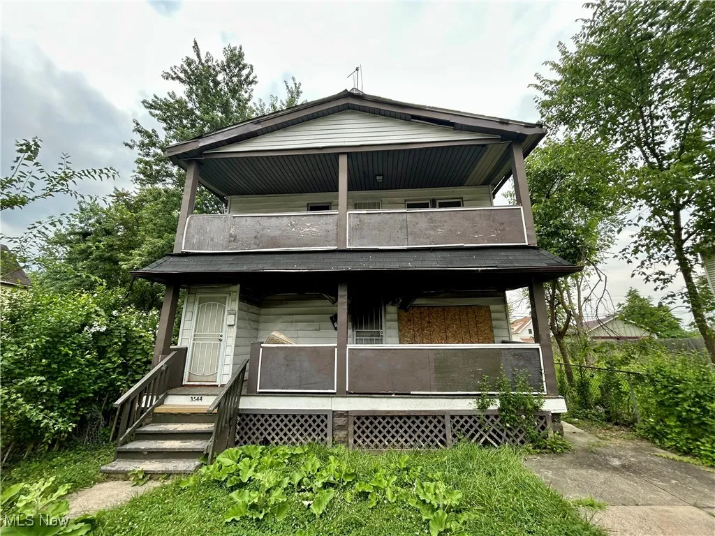 View of front of house featuring a balcony and a porch