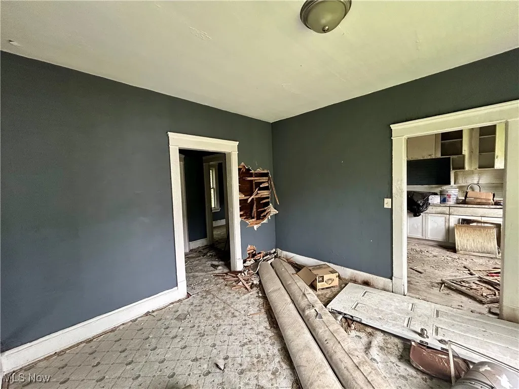 Unfurnished living room featuring a sink and baseboards