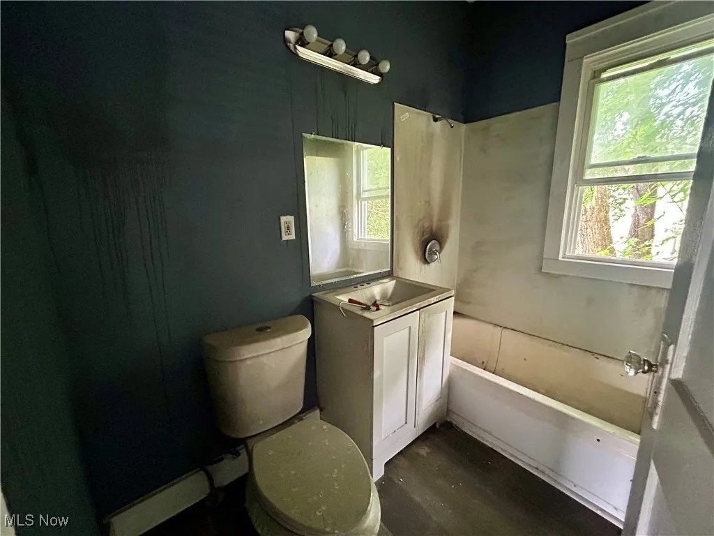 Bathroom featuring wood finished floors, vanity, and shower / bath combination