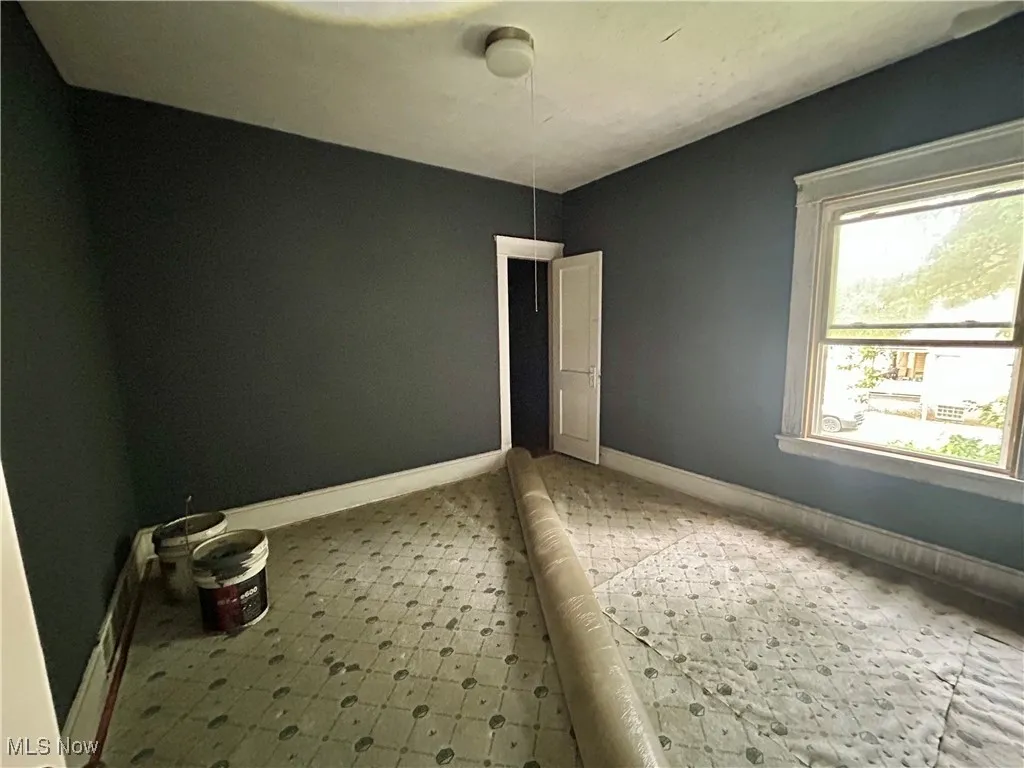 Unfurnished room featuring baseboards and light floors