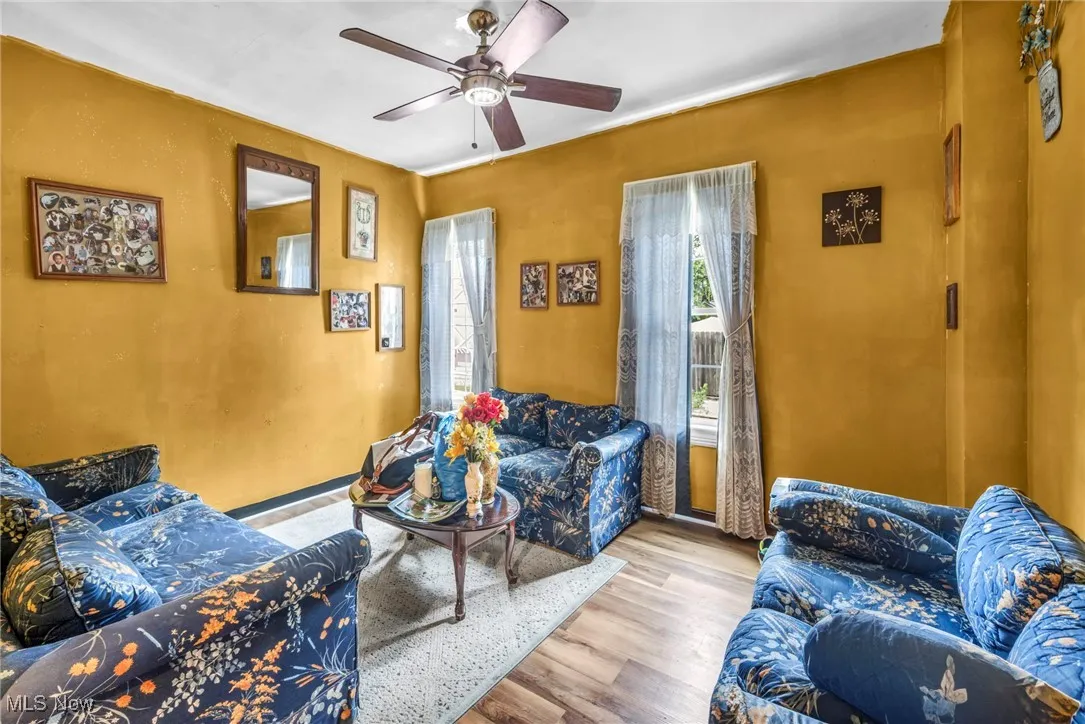 Living area with ceiling fan and wood finished floors