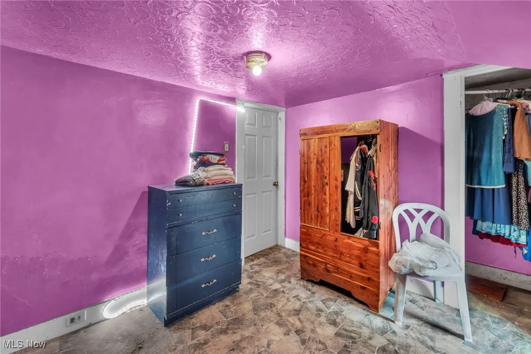 Bedroom featuring a textured ceiling and baseboards