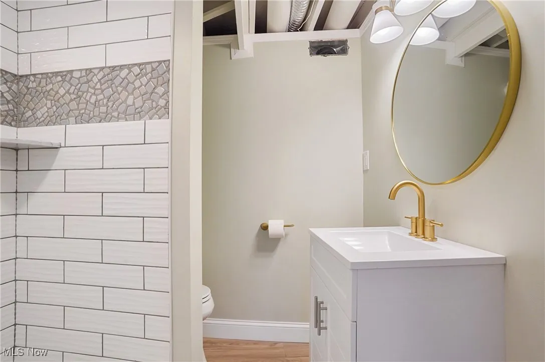 Full bath featuring vanity and wood finished floors