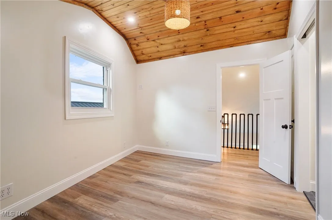 Spare room featuring vaulted ceiling, wood ceiling, light wood-style floors, and recessed lighting