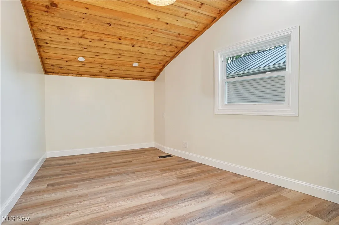 Additional living space with lofted ceiling, light wood-style floors, and wood ceiling