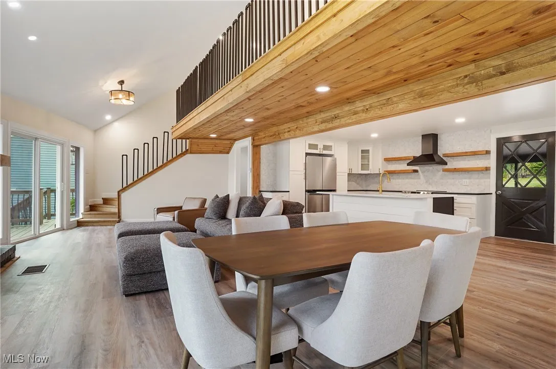 Dining room featuring healthy amount of natural light, recessed lighting, light wood finished floors, and stairway
