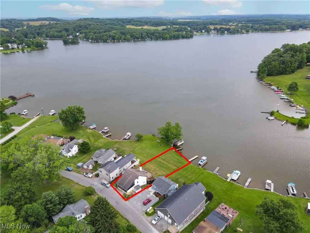 Aerial perspective of suburban area with property boundaries highlighted and a large body of water