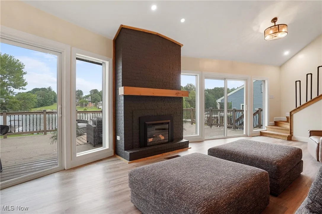 Living room featuring wood finished floors, stairway, a fireplace, recessed lighting, and lofted​​‌​​​​‌​​‌‌​‌‌​​​‌‌​‌​‌​‌​​​‌​​ ceiling