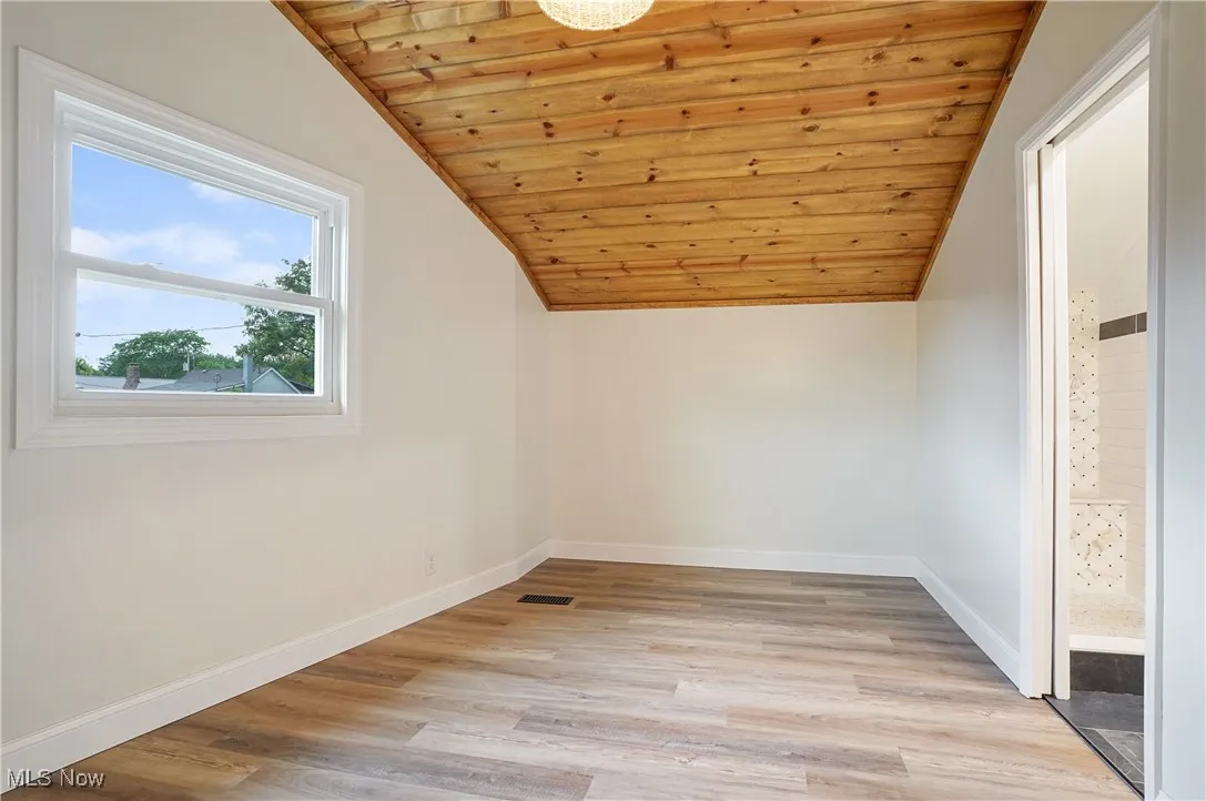 Bonus room with vaulted ceiling, light wood-style floors, and wood ceiling