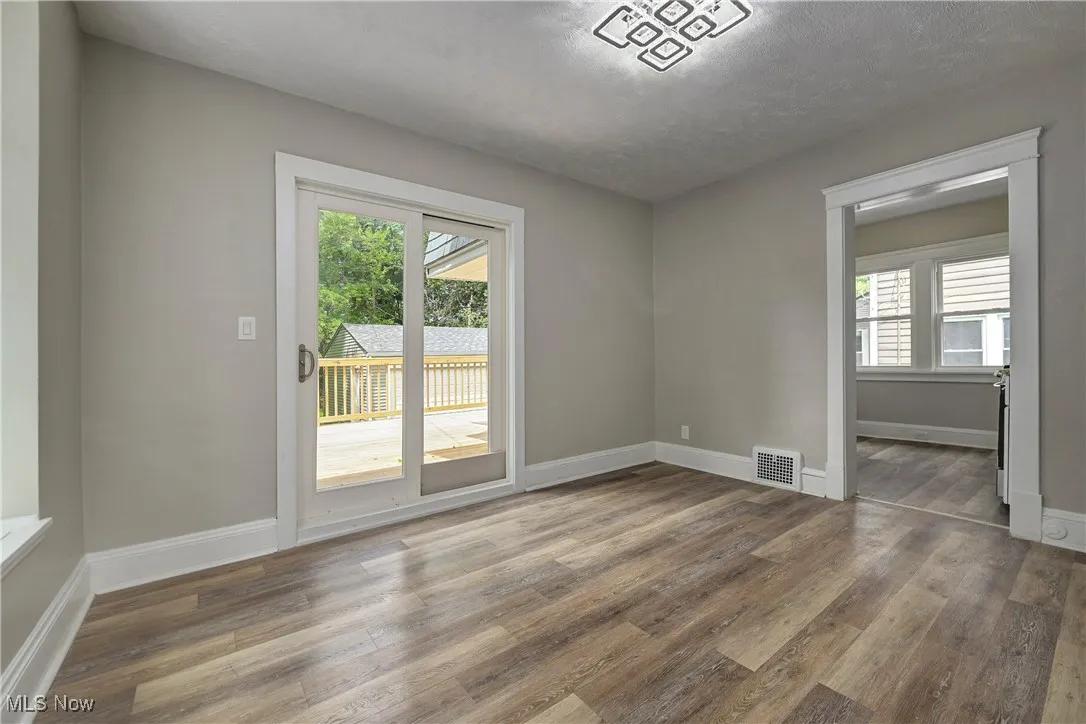 Empty room with healthy amount of natural light and wood finished floors