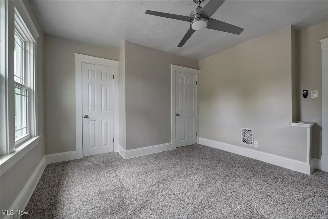 Unfurnished bedroom with carpet and ceiling fan