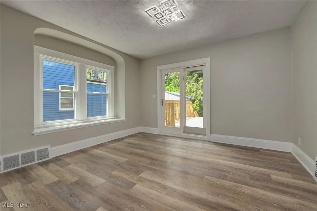 Empty room with wood finished floors and a textured ceiling
