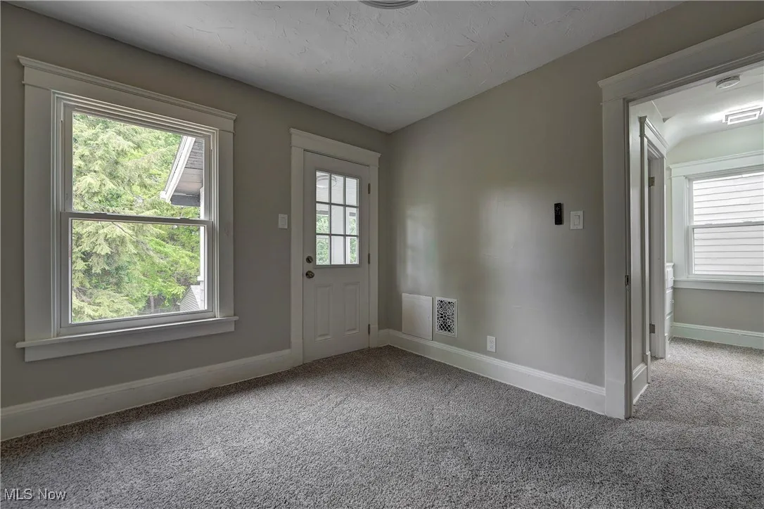 Doorway to outside featuring carpet