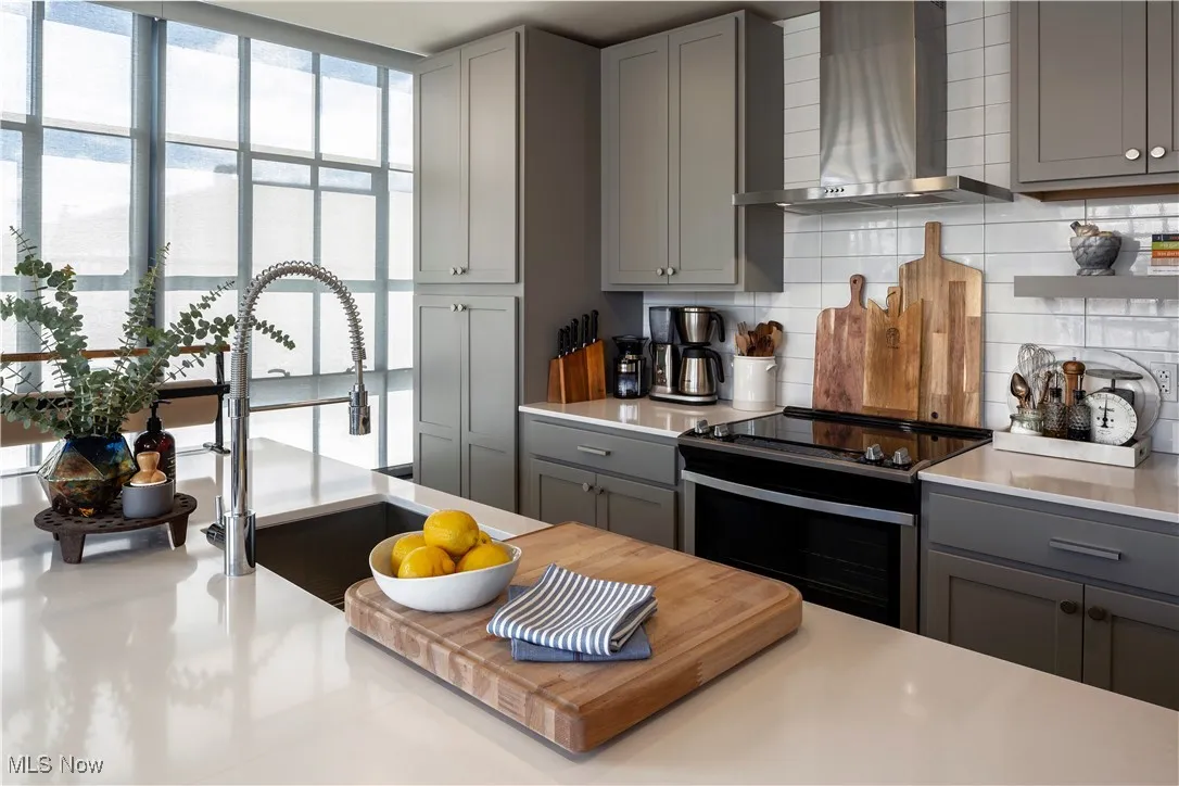 Kitchen with stainless steel appliances, light countertops and light backsplash
