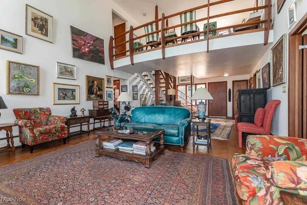 Living area with a high ceiling, stairway, and a baseboard heating unit