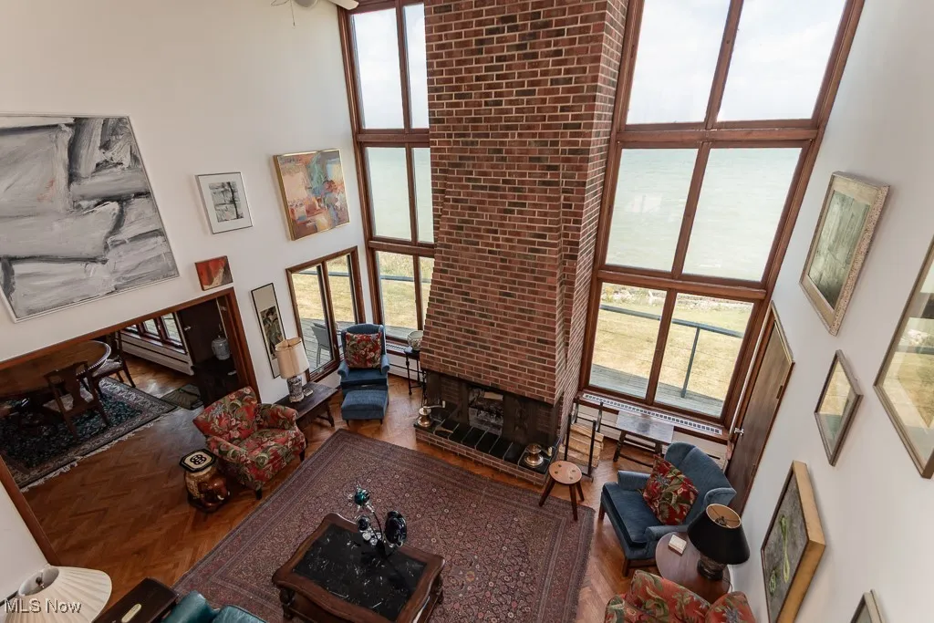 Living area featuring a towering ceiling, plenty of natural light, and a ceiling fan