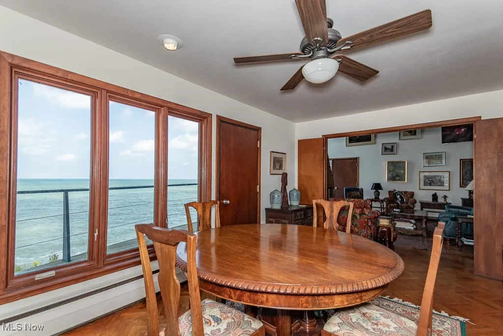 Dining room featuring baseboard heating, ceiling fan, and a water view