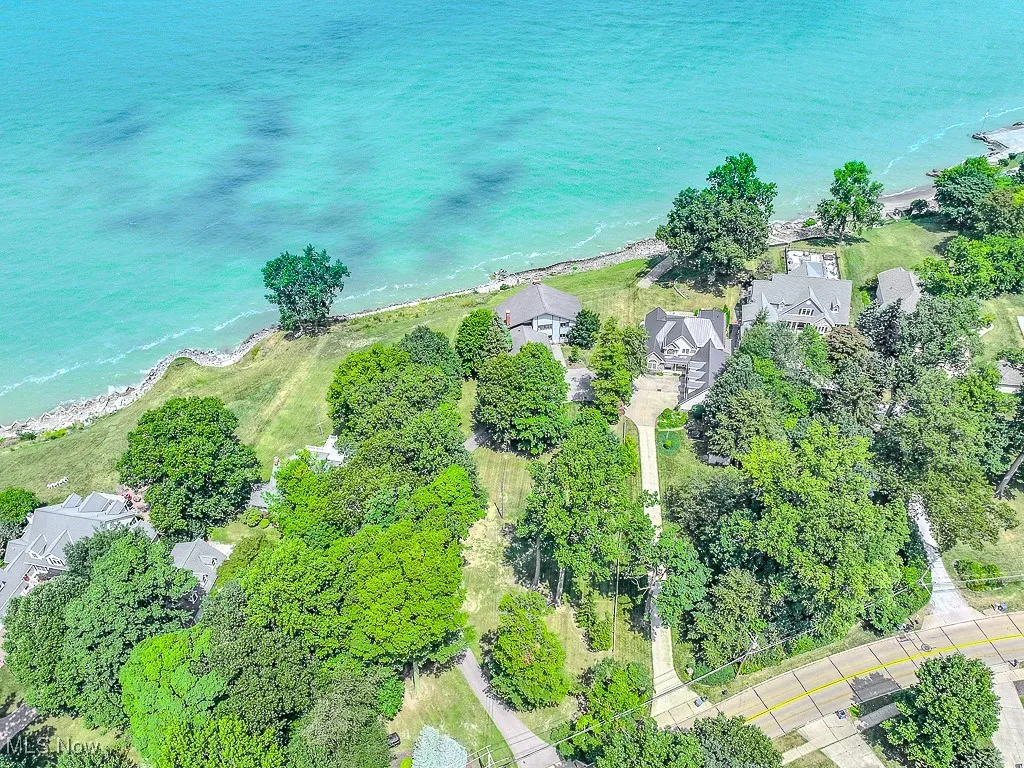 Aerial view of property and surrounding area featuring a large body of water and nearby suburban area