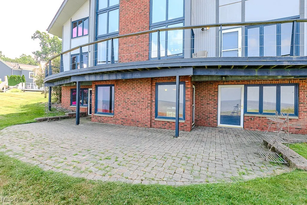 Rear view of property featuring brick siding, a patio, and a yard