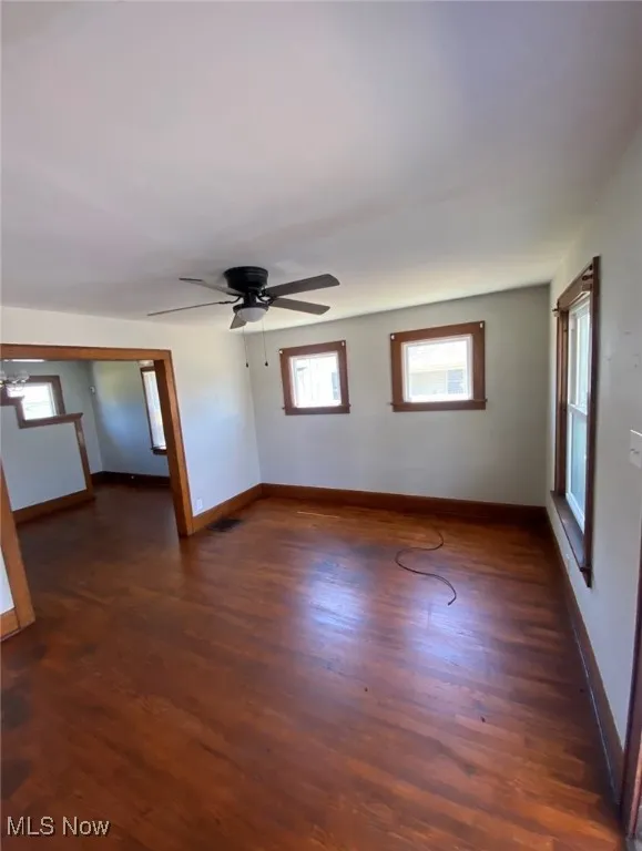 Empty room with a ceiling fan and wood finished floors