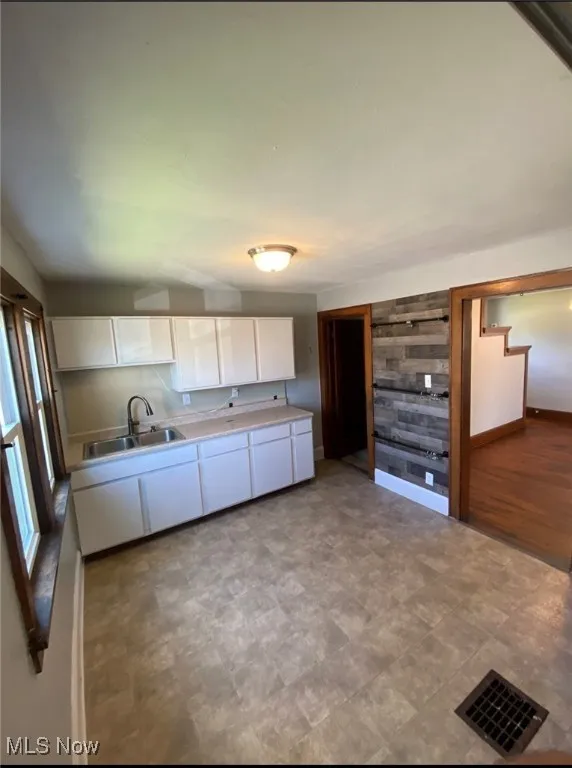 Kitchen featuring white cabinets and light countertops