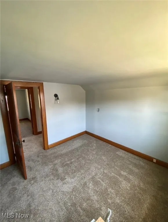 Empty room featuring carpet and baseboards