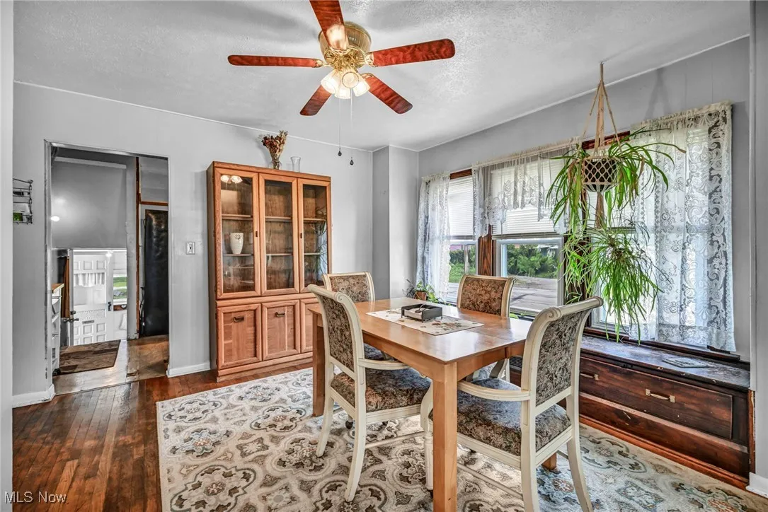 Dining area featuring a textured ceiling, a ceiling fan, and wood-type flooring