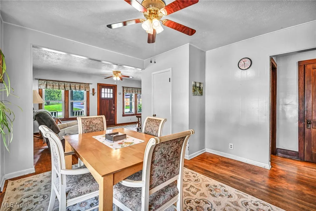 Dining area featuring a ceiling fan, a textured ceiling, and wood finished floors