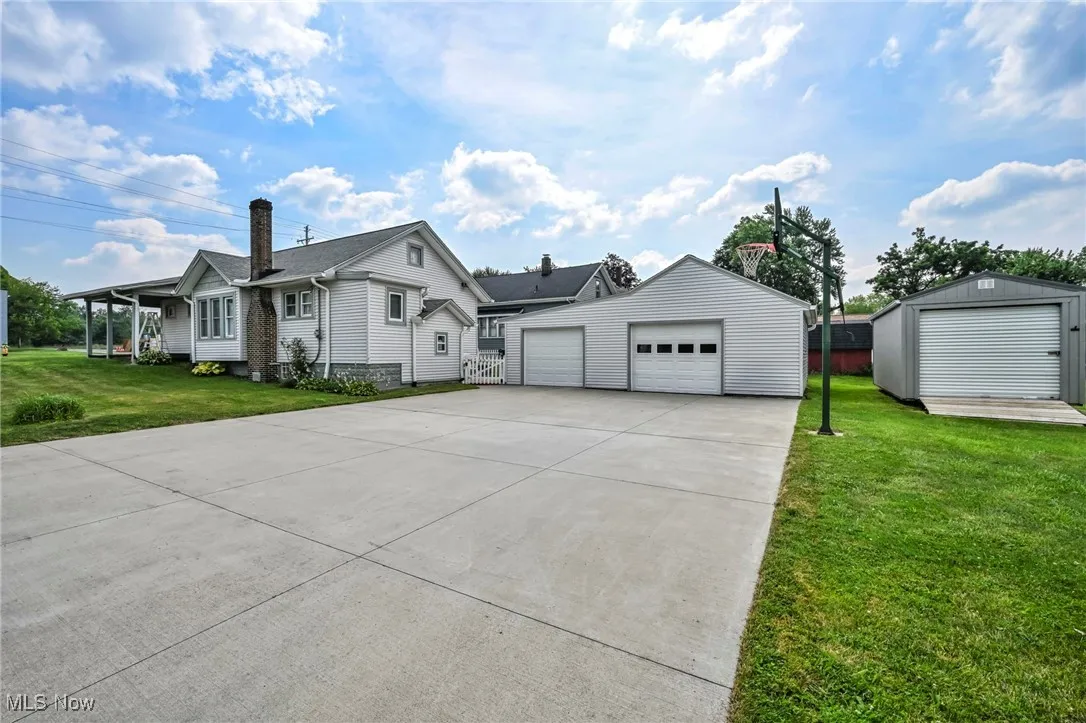 View of front of house featuring a front lawn, and a detached garage