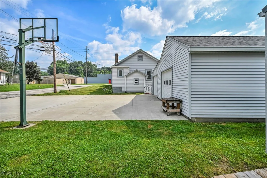 View of lawn, driveway, garage and back of house.