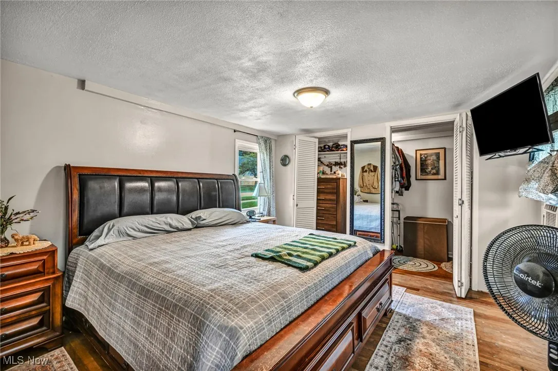 Bedroom with wood finished floors and a textured ceiling