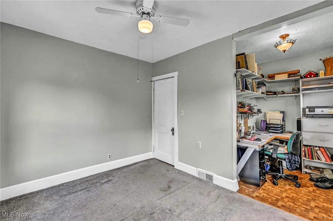 Office area with ceiling fan and baseboards