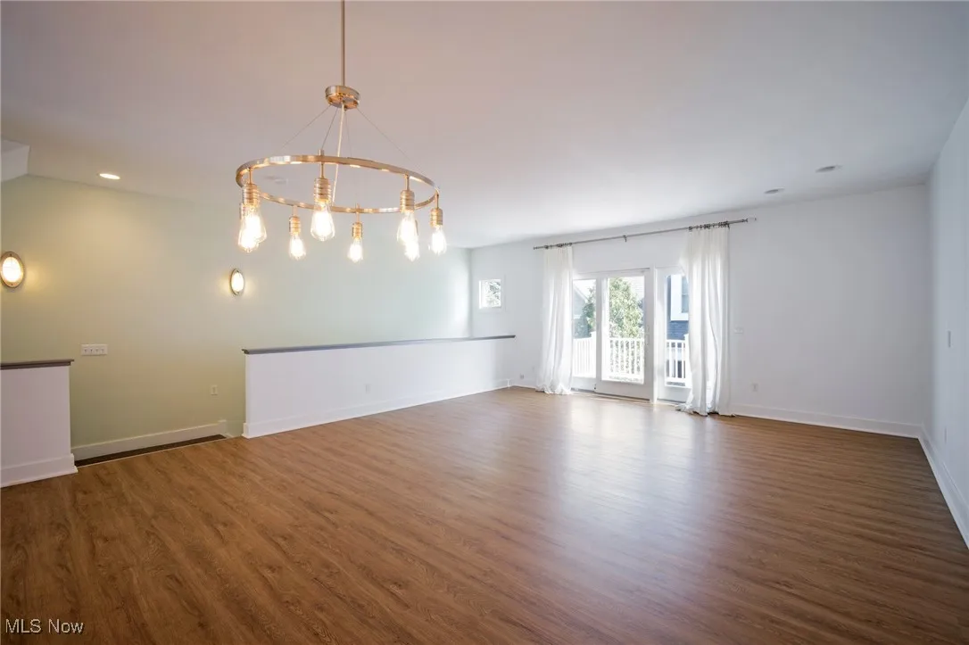 Spare room featuring a chandelier, wood finished floors, and recessed lighting
