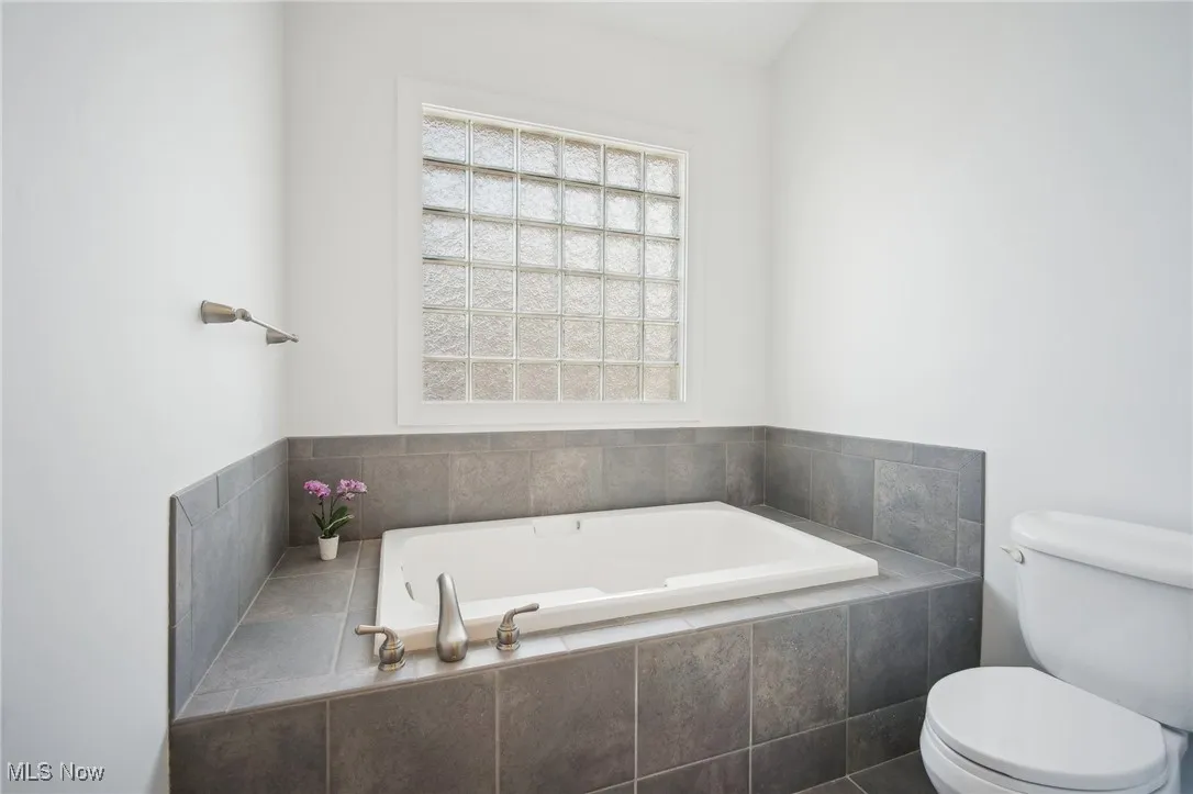Full bath with toilet and a garden tub