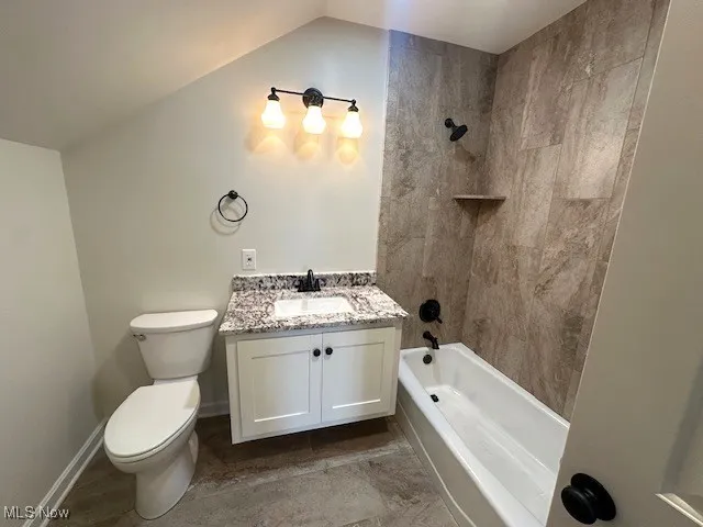 Full bath featuring vanity, shower / bathtub combination, and lofted ceiling