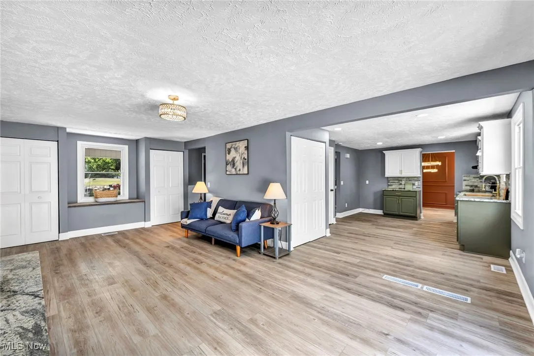 Sitting room with light wood-style floors and a textured ceiling